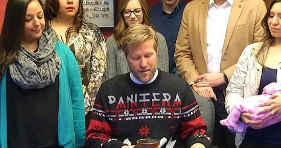 Mayor Tim Keller wears a Pantera Christmas sweater at a local bill-signing ceremony.
